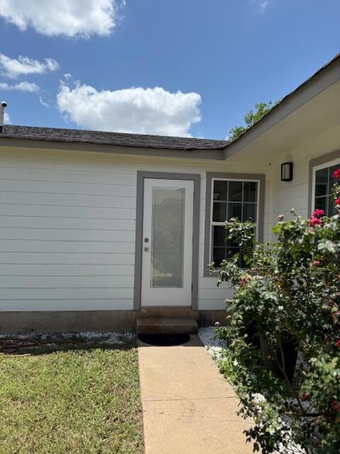 Doorway to property with a yard