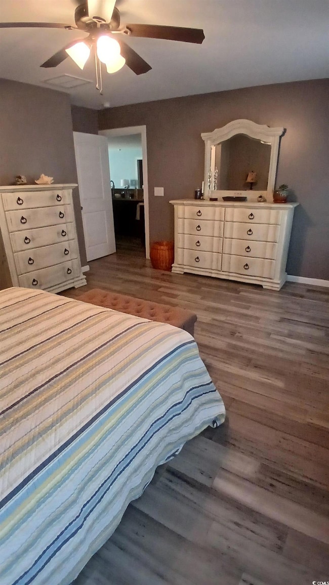 Bedroom with dark wood-style floors and a ceiling fan