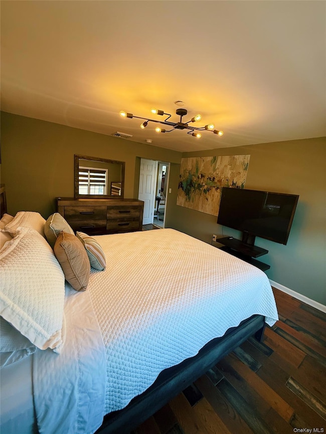 Bedroom with a chandelier and wood finished floors