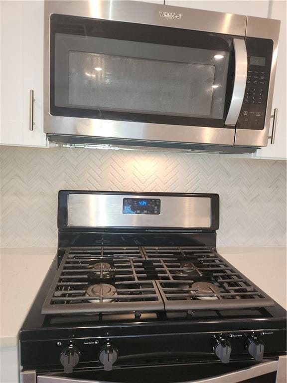 View of stainless steel Microwave, and gas range appliances, and light stone