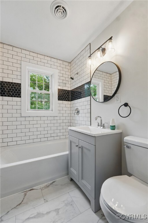 Full bathroom with toilet, marble finish floors, v