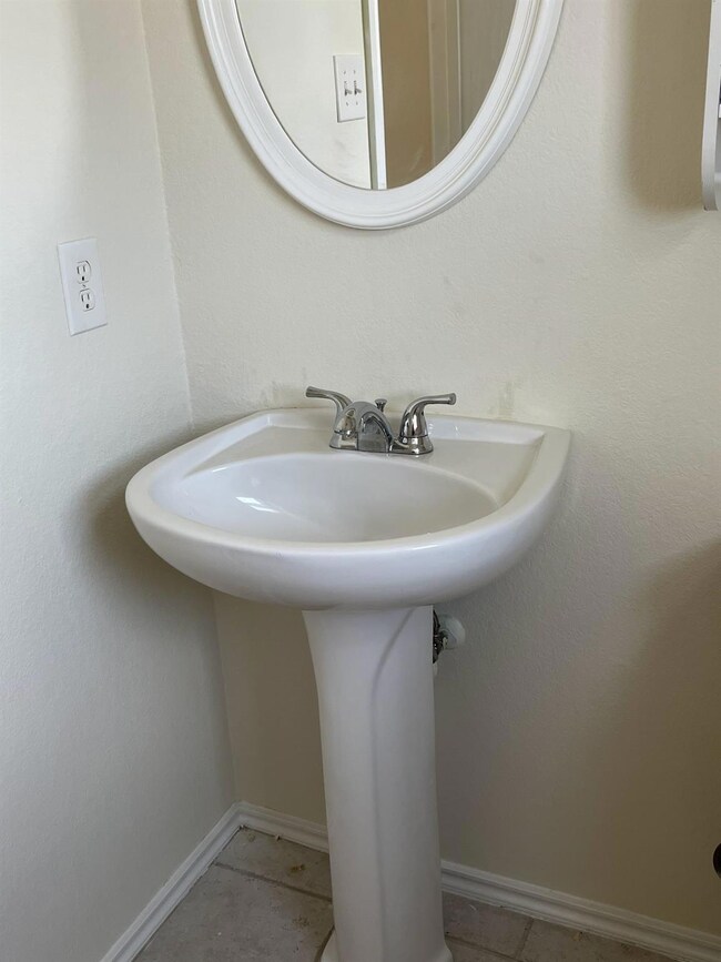 Bathroom with baseboards and tile patterned floor
