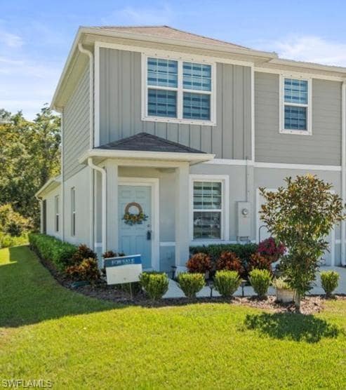 View of front facade featuring board and batten siding and a front yard