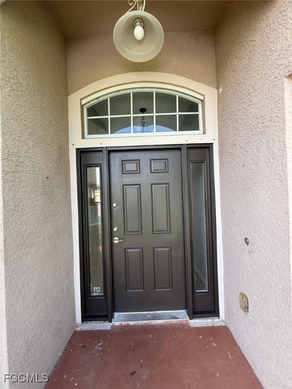 View of exterior entry featuring stucco siding