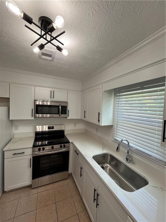 Kitchen with a textured ceiling, crown molding, st