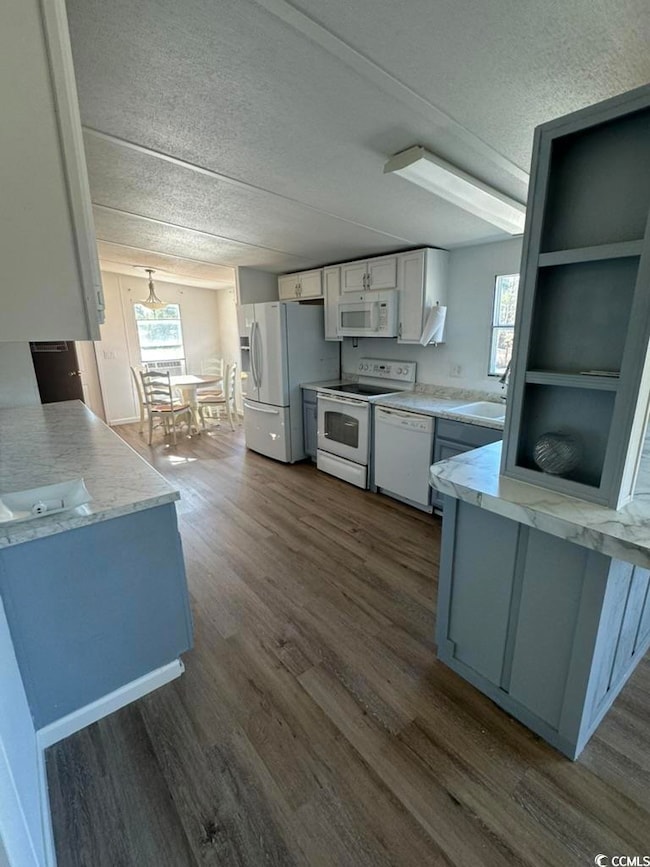 Kitchen with white appliances, white cabinets, a t