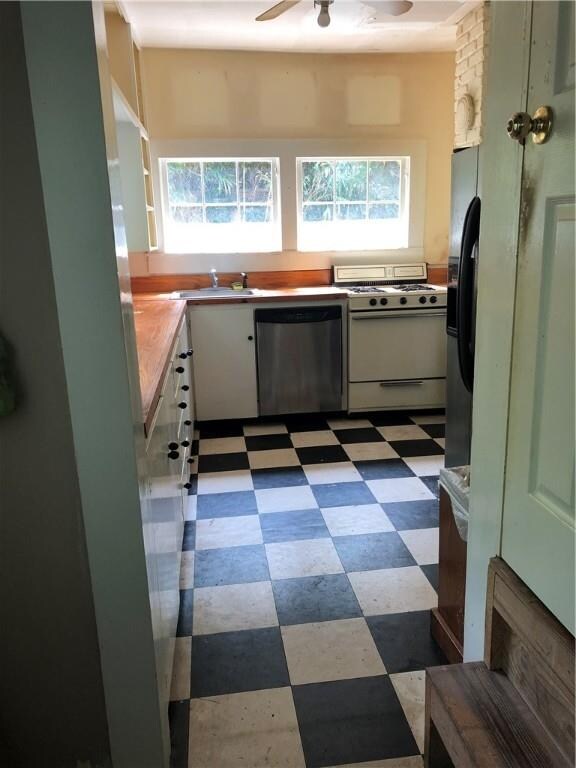 View of the kitchen that is surrounded by windows.