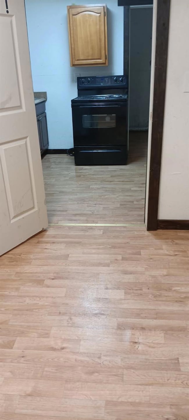 Kitchen with baseboards, black electric range oven