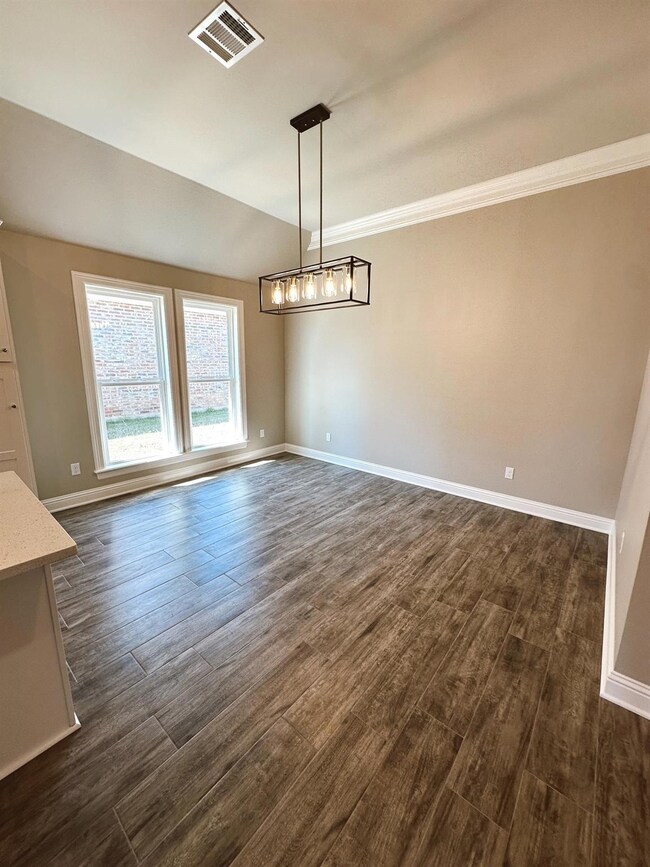Spare room with a chandelier, crown molding, and d