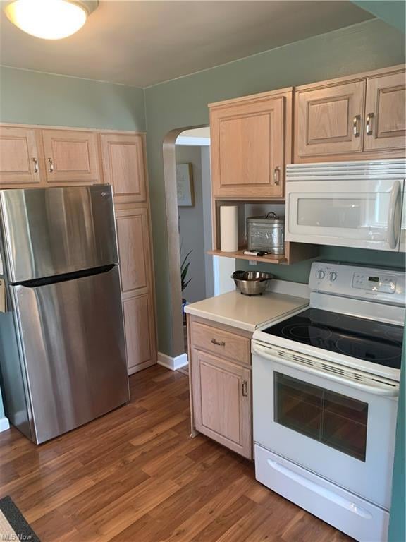 Kitchen with light countertops, laminate flooring, range, microwave and fridge