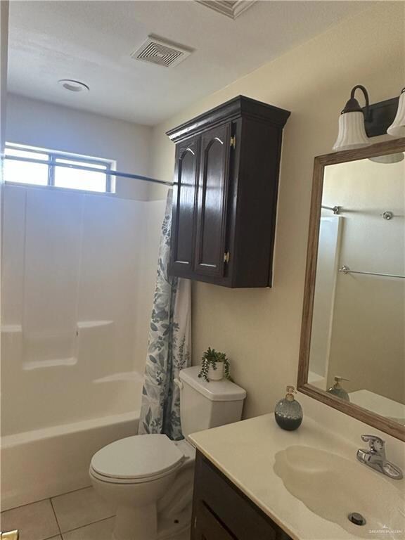 Full bathroom with tile patterned flooring, vanity, shower / tub combo, and toilet