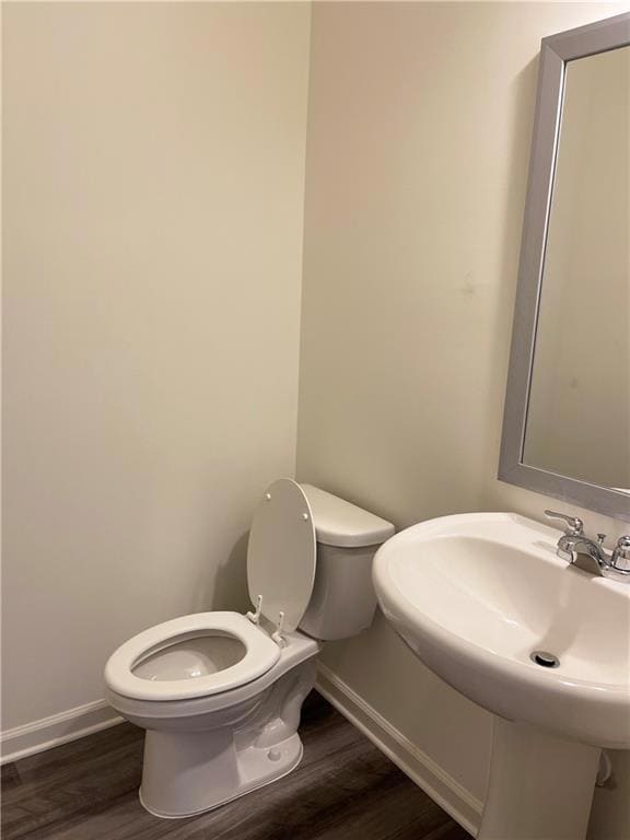 Bathroom with baseboards, toilet, and wood finishe