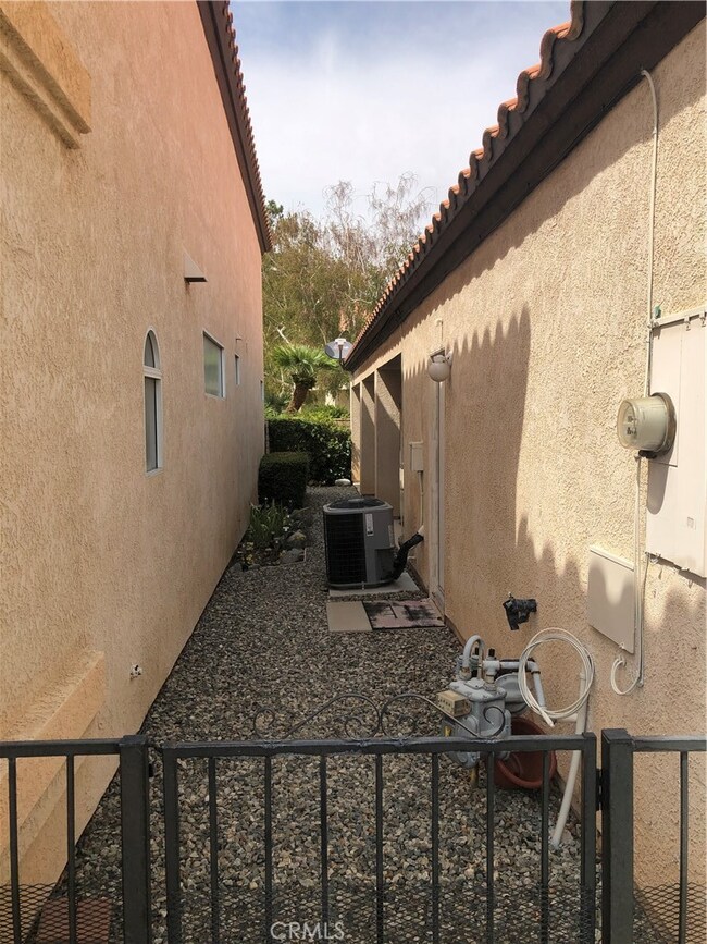 Side yard with covered patio and two access gates one to the front and the other to the rear walkway