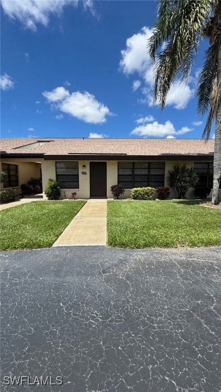 Single story home with a front lawn and stucco sid