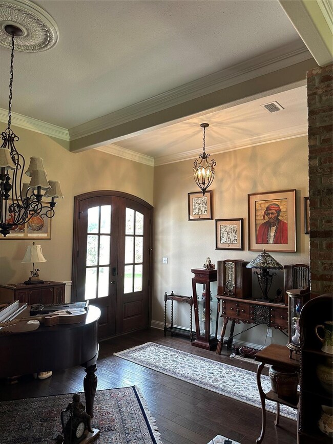 Foyer featuring an inviting chandelier, crown mold