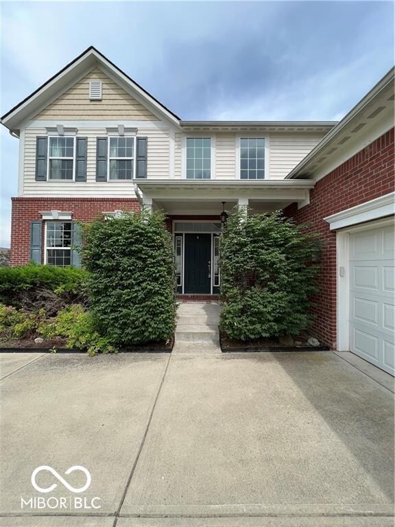 view of front of property with a garage, brick siding, and driveway