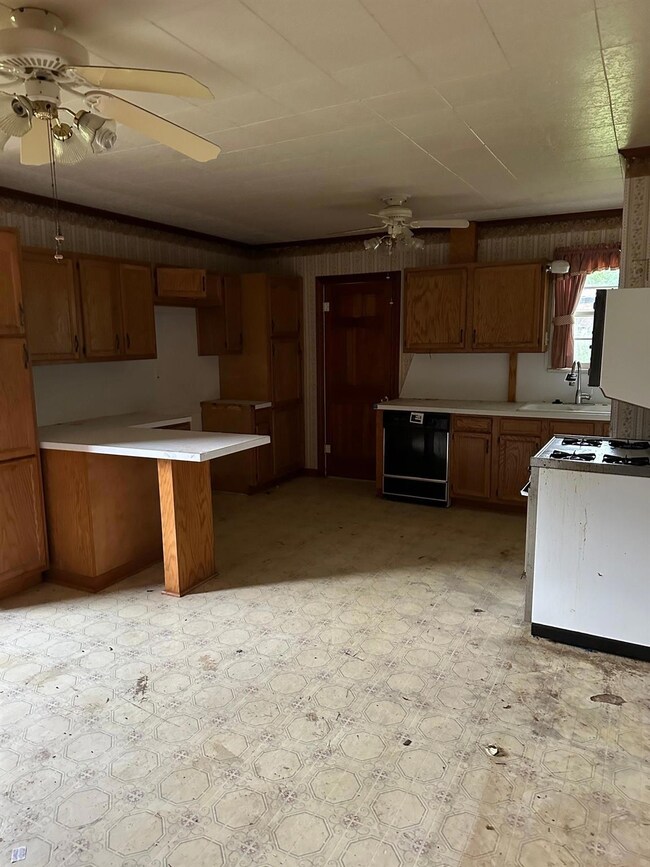 Kitchen with range, light tile flooring, sink, and