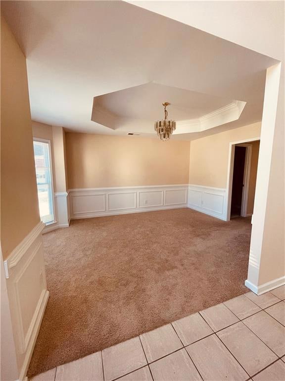 Spare room featuring a chandelier, a decorative wa