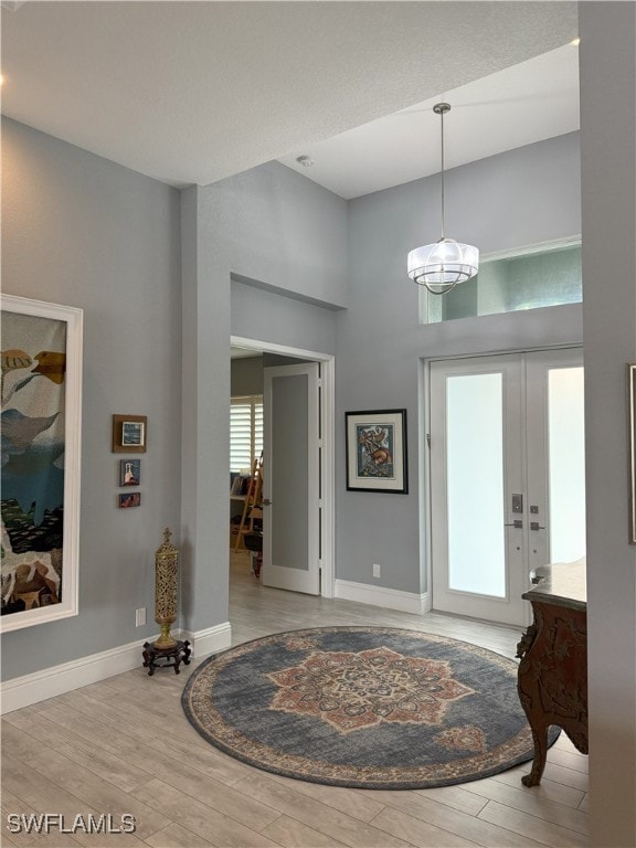 Entrance foyer featuring a high ceiling, baseboard