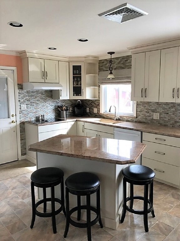 Bright kitchen adorned with granite, under-counter