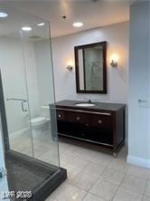Full bath featuring vanity, a shower stall, and light tile patterned floors