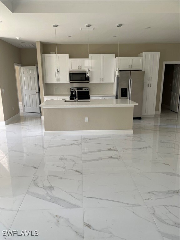 Kitchen featuring white cabinetry, a center island