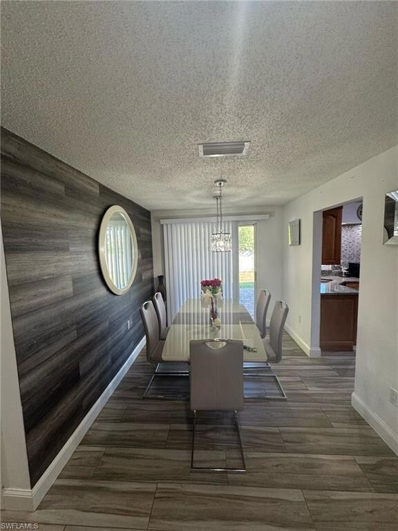 Dining space featuring a textured ceiling, baseboa