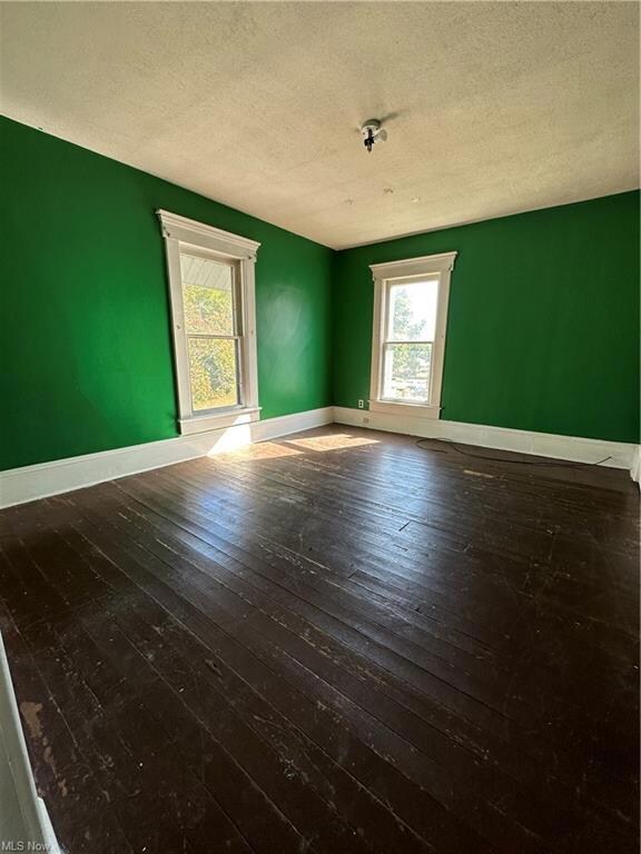 Wood floored spare room featuring a textured ceili