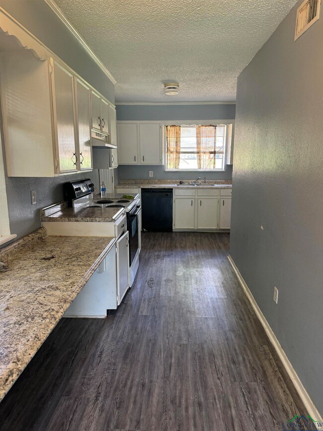 Kitchen featuring a textured ceiling, range with e