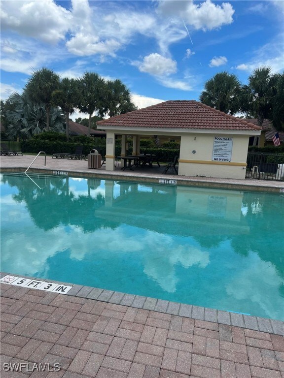 Community pool with a patio and fence