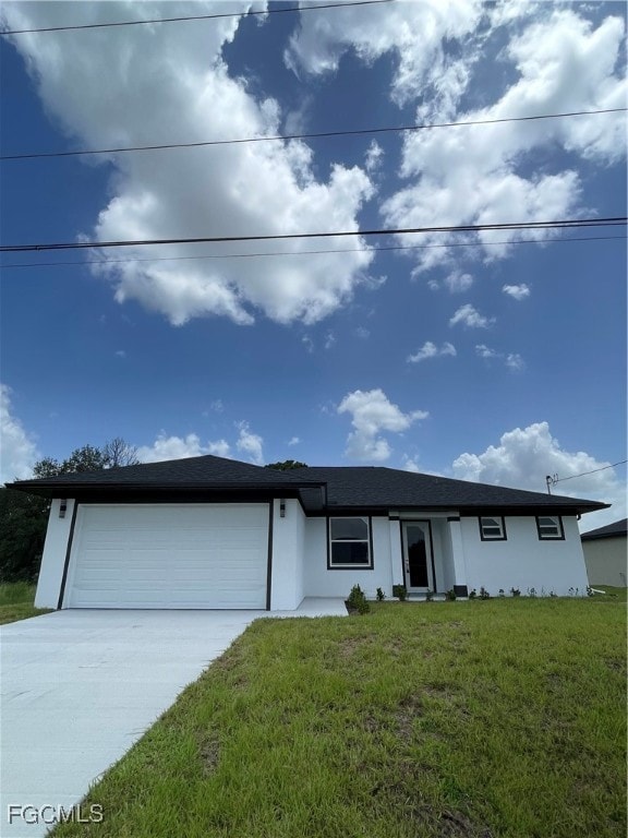View of front of property featuring a front yard, stucco siding, concrete driveway, and a garage