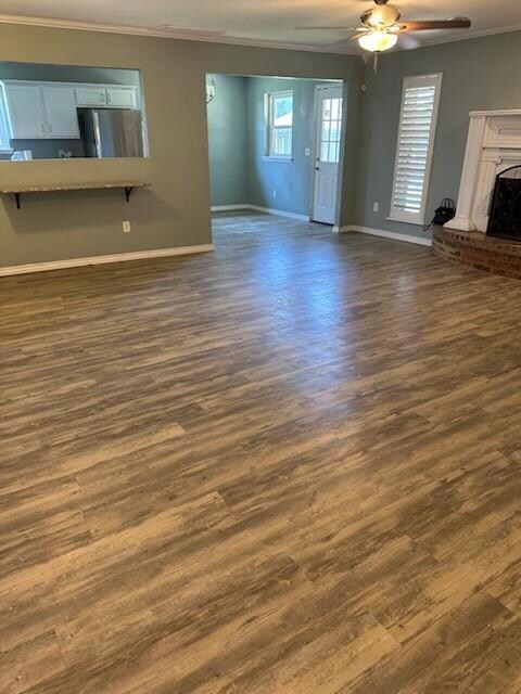 Unfurnished living room with ceiling fan, ornament