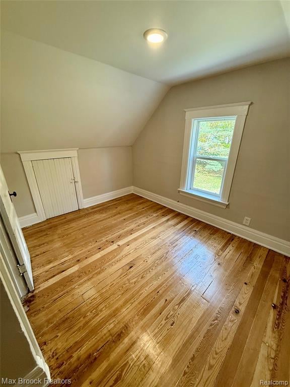 Additional bedroom space featuring light wood flooring and lofted ceiling