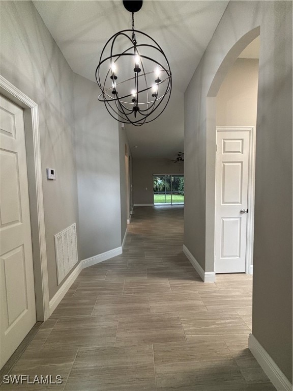 Hall featuring arched walkways and a chandelier