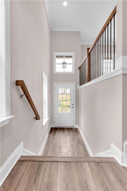 Doorway with wood finished floors, a high ceiling,