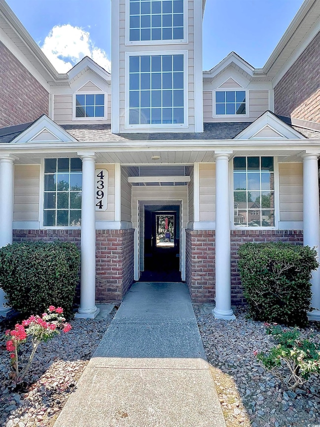 Entrance to property with brick siding and covered