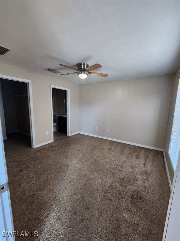 Unfurnished bedroom with a walk in closet, carpet