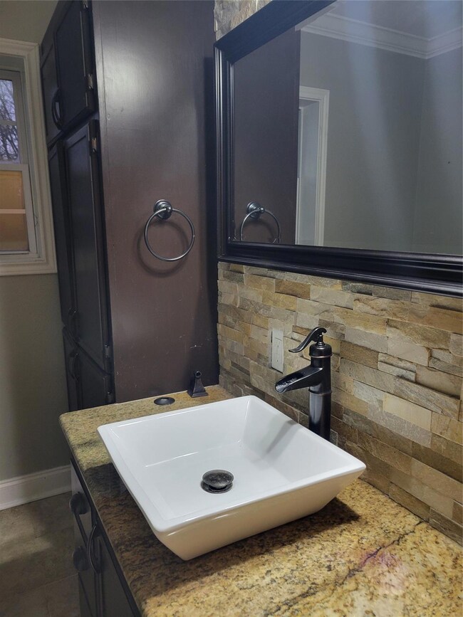 Bathroom with backsplash, vanity, and ornamental m