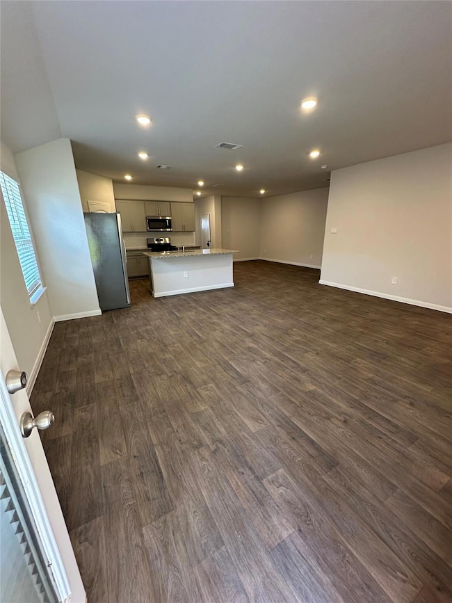 Unfurnished living room with dark wood finished f