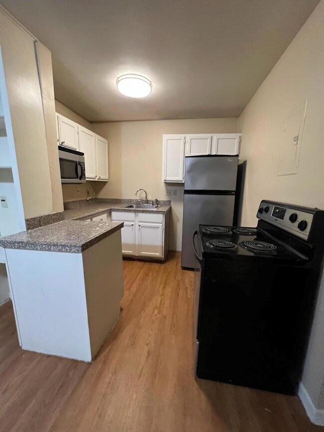 Kitchen featuring white cabinets, a sink, light w