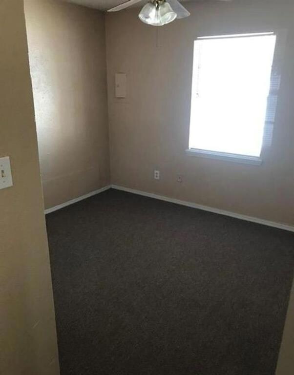 Carpeted empty room with ceiling fan