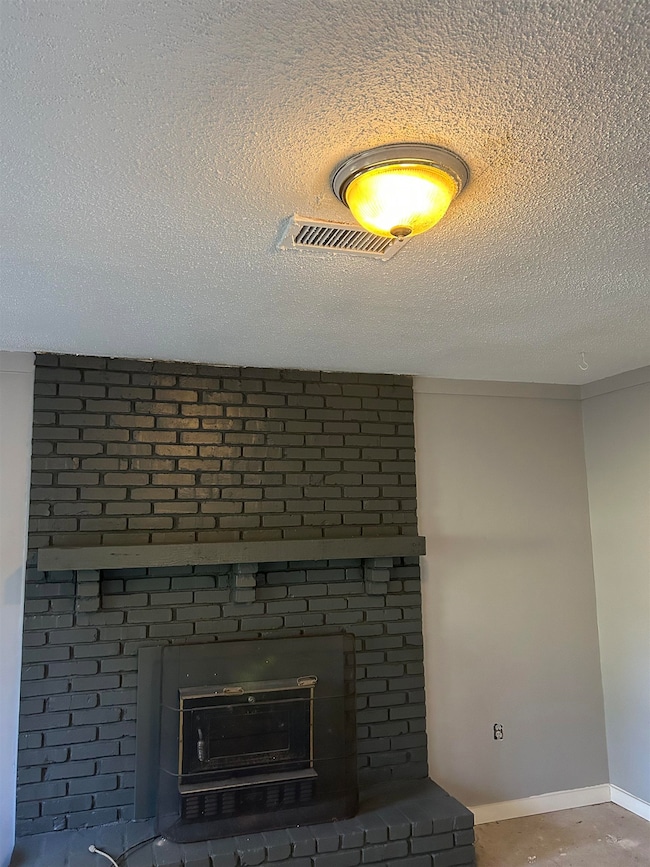 Details featuring a brick fireplace and a textured