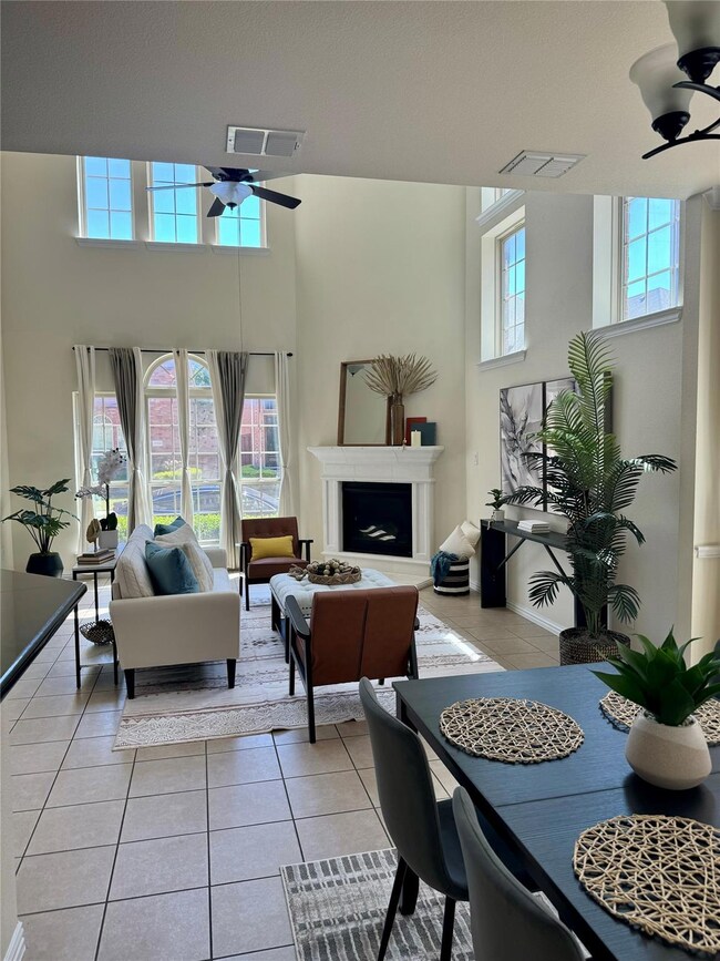 Living room with ceiling fan and light tile patter