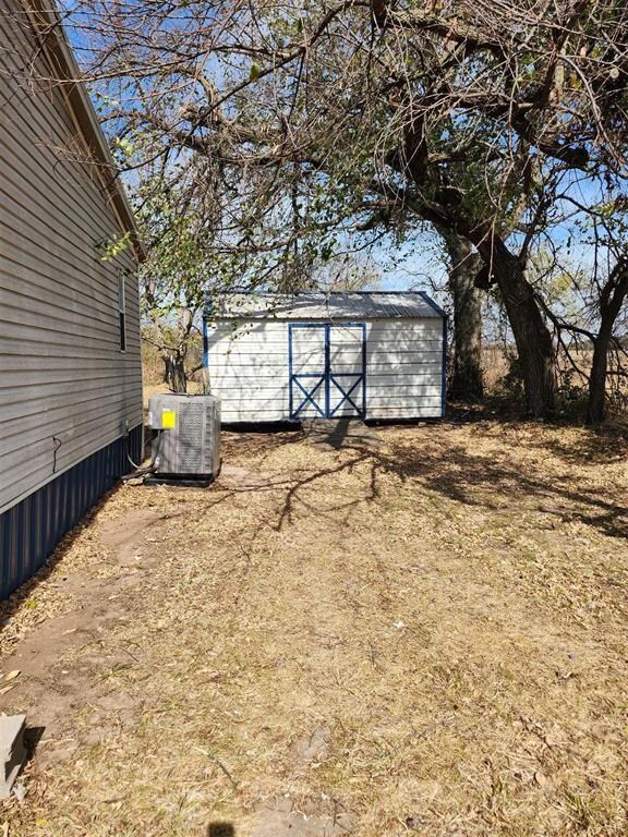 View of yard featuring a storage shed and cooling 