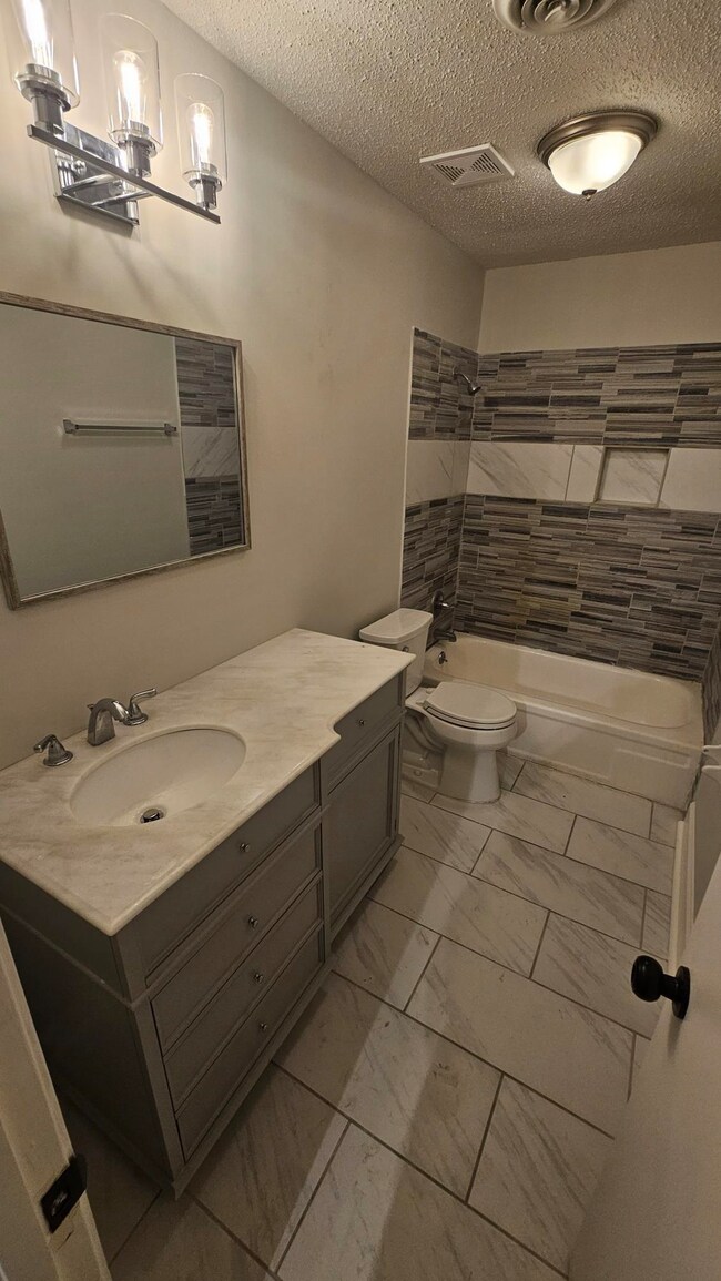 Full bathroom with vanity, tiled shower / bath com