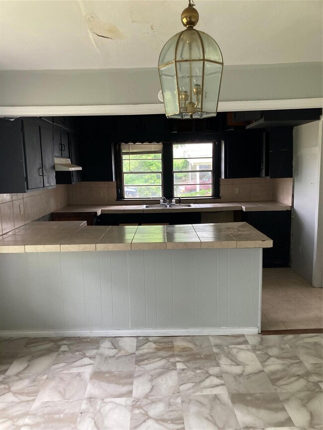 Kitchen with light tile flooring, tasteful backspl