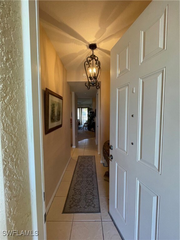 Corridor featuring light tile patterned floors and