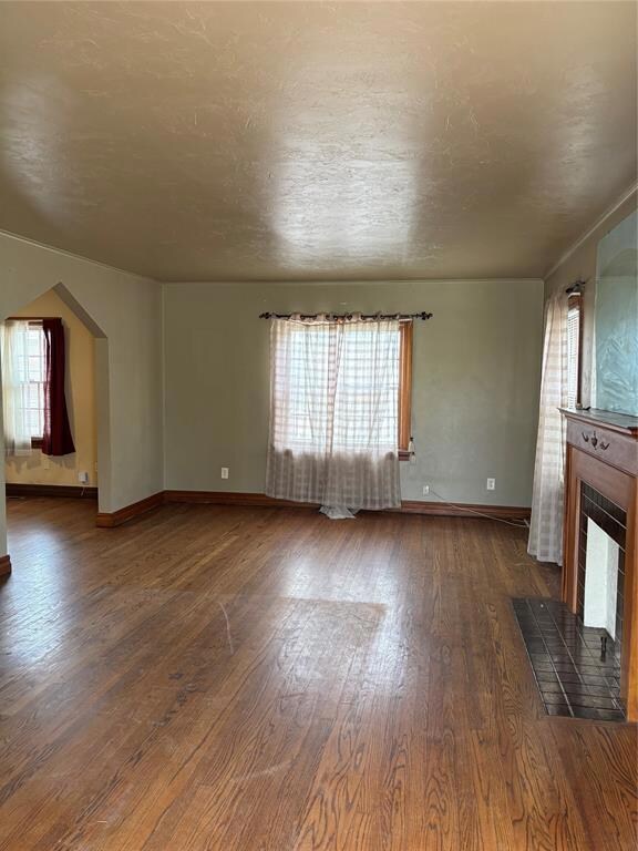 Unfurnished living room featuring a tile fireplace