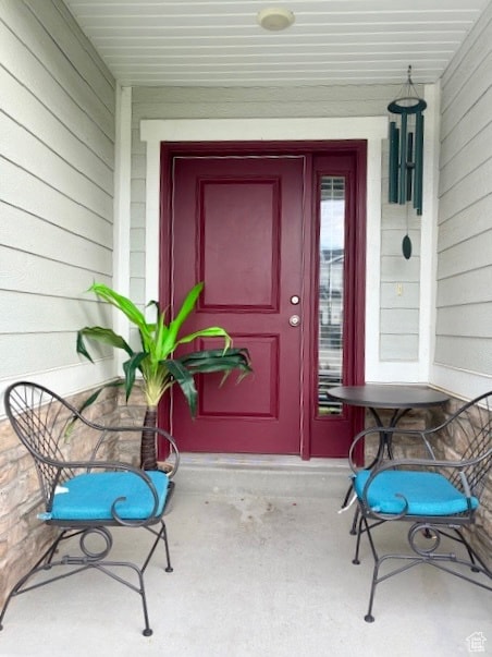 Doorway to property featuring covered porch