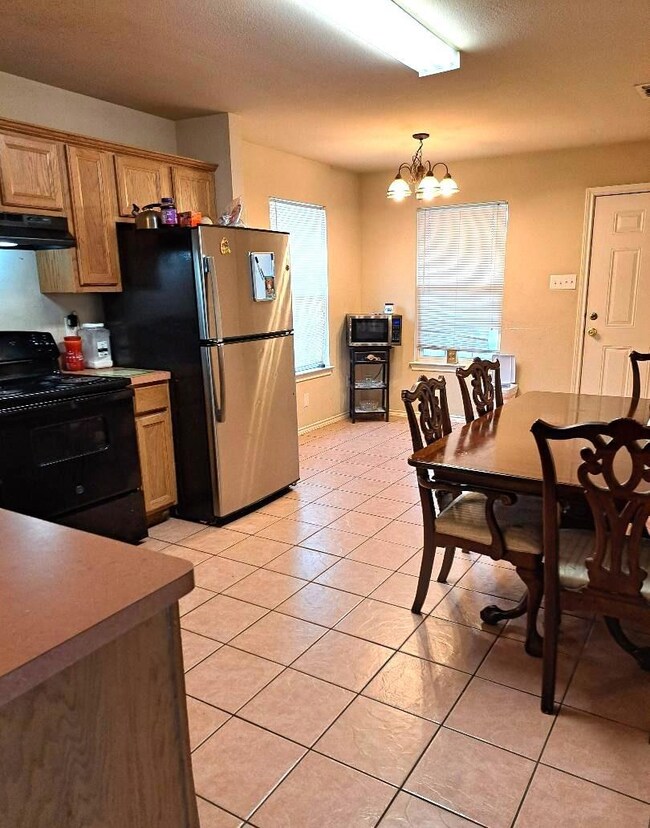 Kitchen with stainless steel fridge, light tile pa